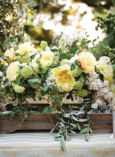 A romantic mix of clematis, garden roses, and olive branches captures the garden-inspired theme of the workshop.