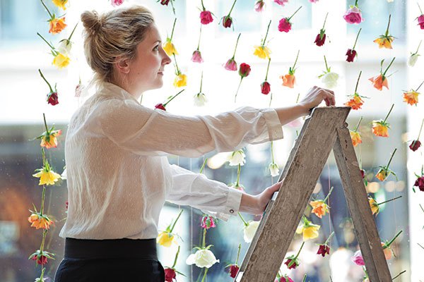 Artist Rebecca Louise Law completes a floral wall in the window of her London gallery. Photo courtesy of Rebecca Louise Law