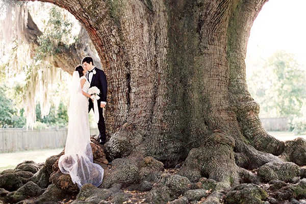 Before the ceremony, the bride and groom pose for pictures underneath a massive oak tree in New Orleans’ Audubon Park.