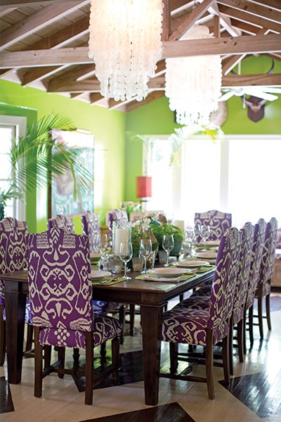 Liza Pulitzer Calhoun’s light and colorful dining room features her signature color purple, parrot-green lacquered walls, and floors painted by her sister, Minnie McCluskey.