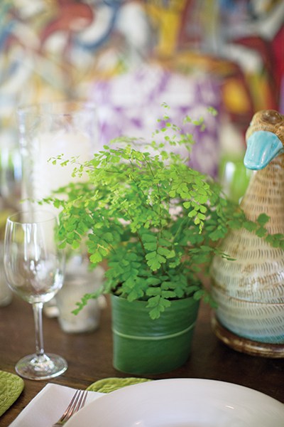 Liza decorates her table with green ferns in pots cleverly wrapped in ginger lily leaves from her garden.