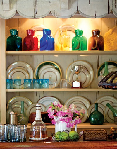 Fresh-cut pink bougainvillea in a white ceramic pitcher pairs well with the lime and turquoise on the bar.