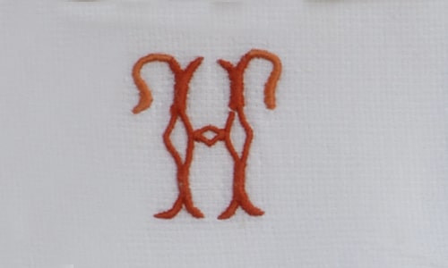 Single-Initial Embroidered Napkin with red-orange embroidery