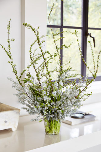 Completed silver and white flower arrangement of Japanese spirea, kochia, and white muscari