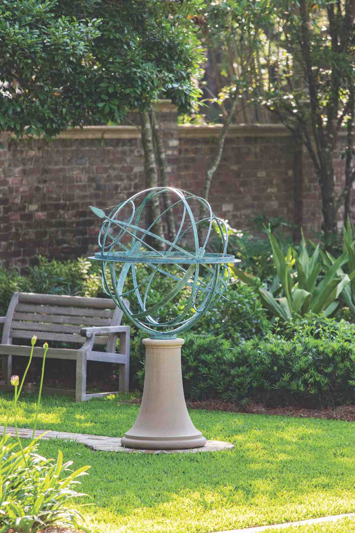 A David Harber armillary sphere emblazoned with the phrase, “There is a time and place for everything” offers direction in a Sea Island, Georgia garden.