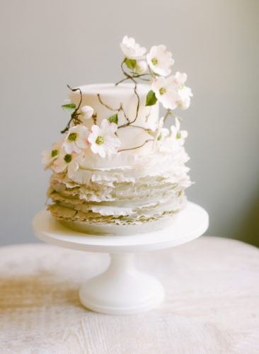 small, 2-tier wedding cake decorated in dogwood sugar flowers