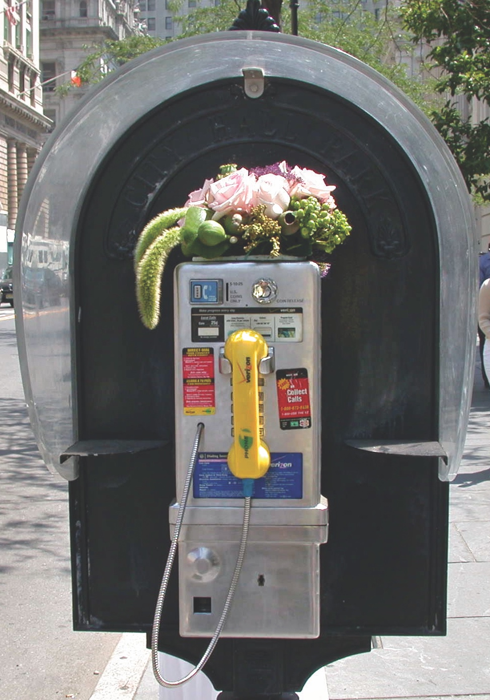 bouquet of flowers on top of a pay phone