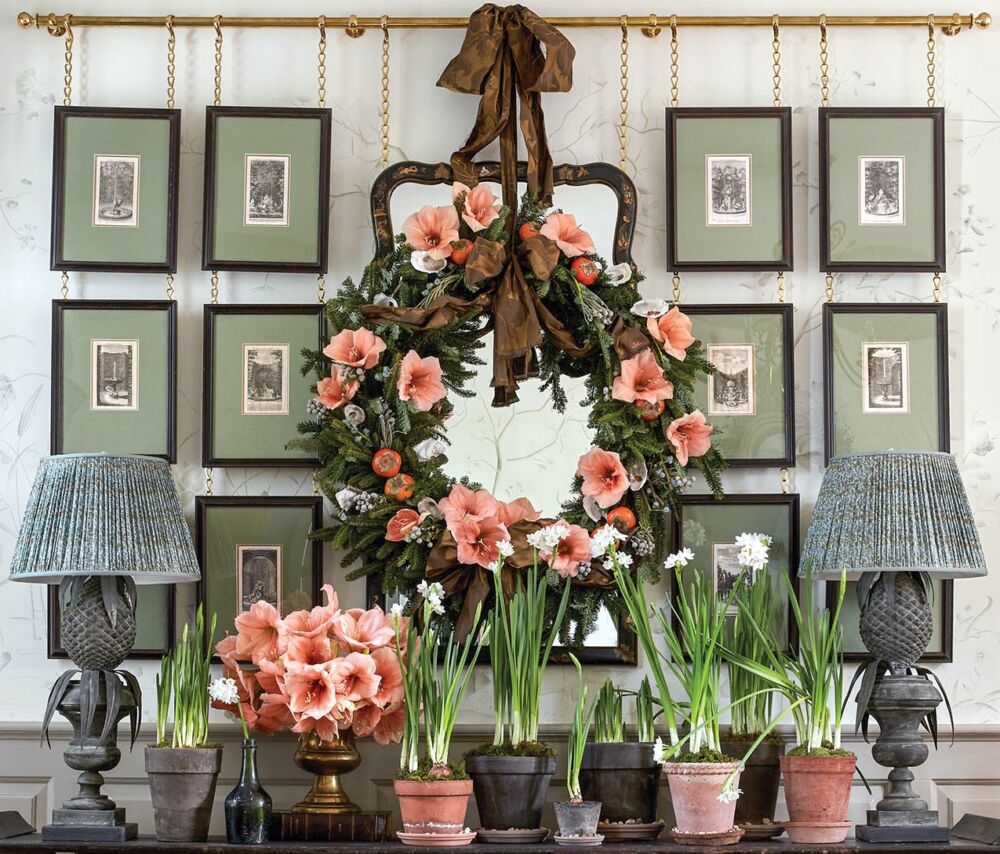 An amaryllis and evergreen wreath, sprinkled with berzelia, over the Chinese console table.