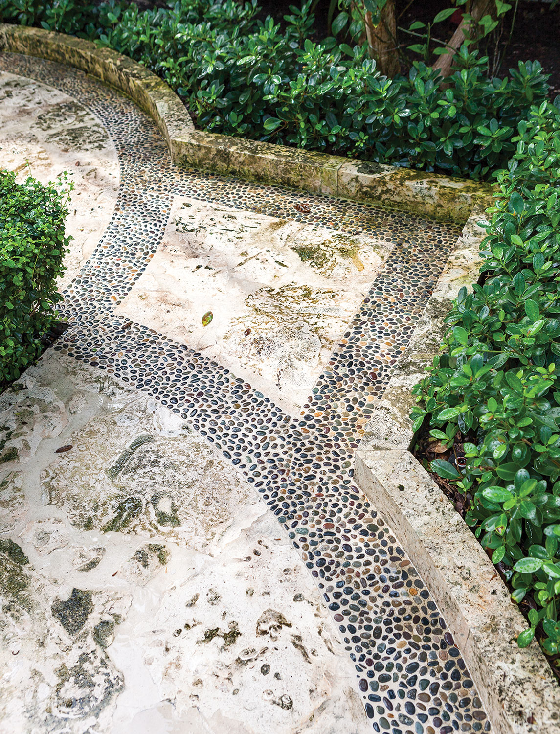 Photo of limestone patio designed by Fernando Wong with a pebble inlay border.