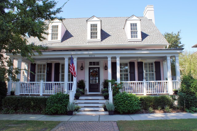 Pale pink cottage with white porch railings and dormer windows on the second floor, located on Bay Street in Norfolk, Virginia