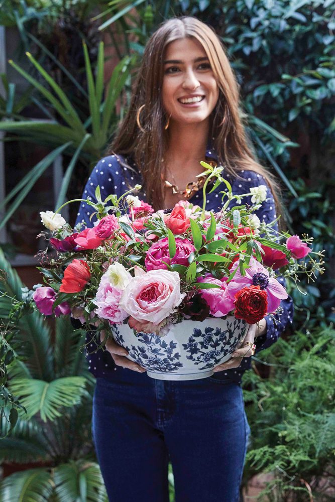 Rowan Blossom holding a blue-and-white bowl of flowers in shades of pink