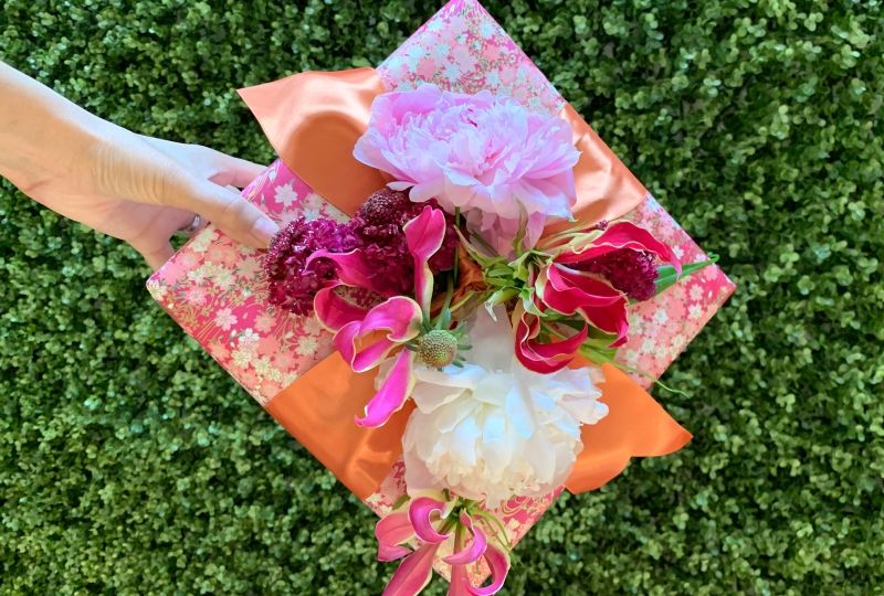 If you're looking for creative gift wrapping ideas, try re-creating this wrapped gift box with fresh flowers tucked into the ribbon