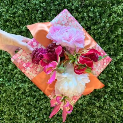If you're looking for creative gift wrapping ideas, try re-creating this wrapped gift box with fresh flowers tucked into the ribbon