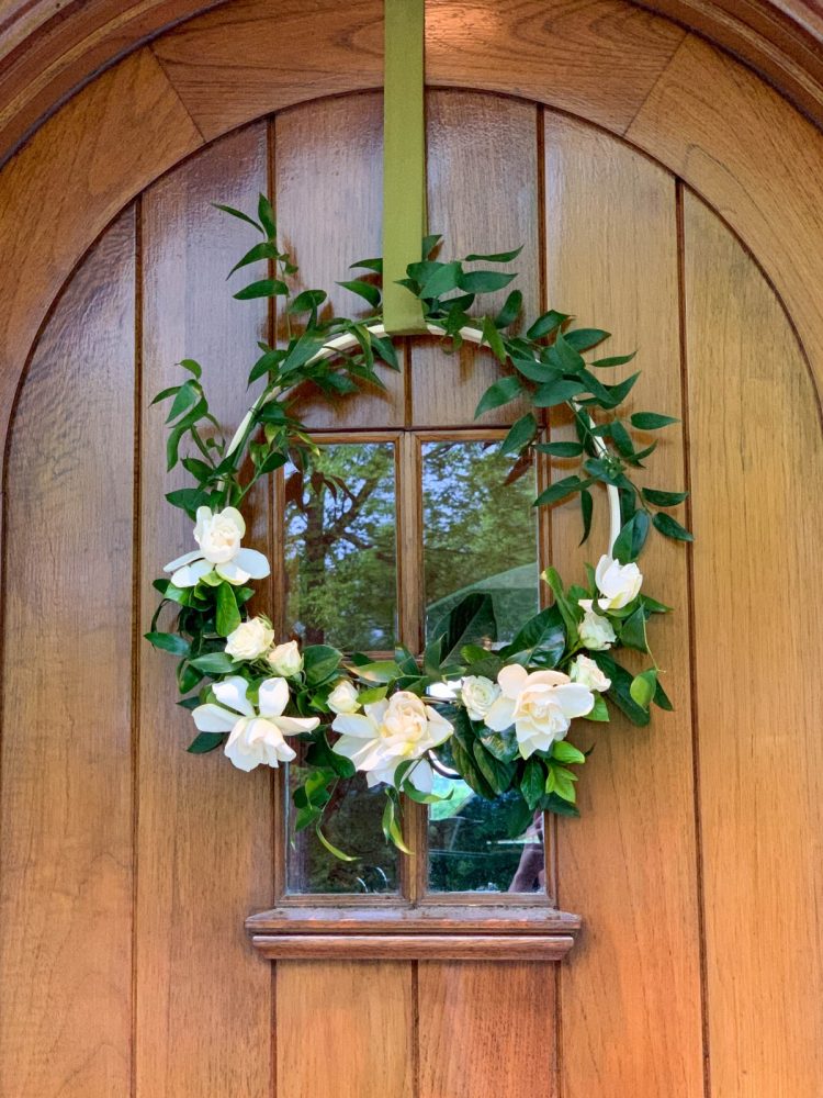 Floral hoop hung on a natural wood front door