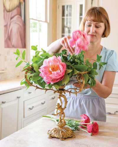 Step 4 photo: Destiny Pinson tucks stems of ‘Coral Charm’ peonies into the floral arrangment 