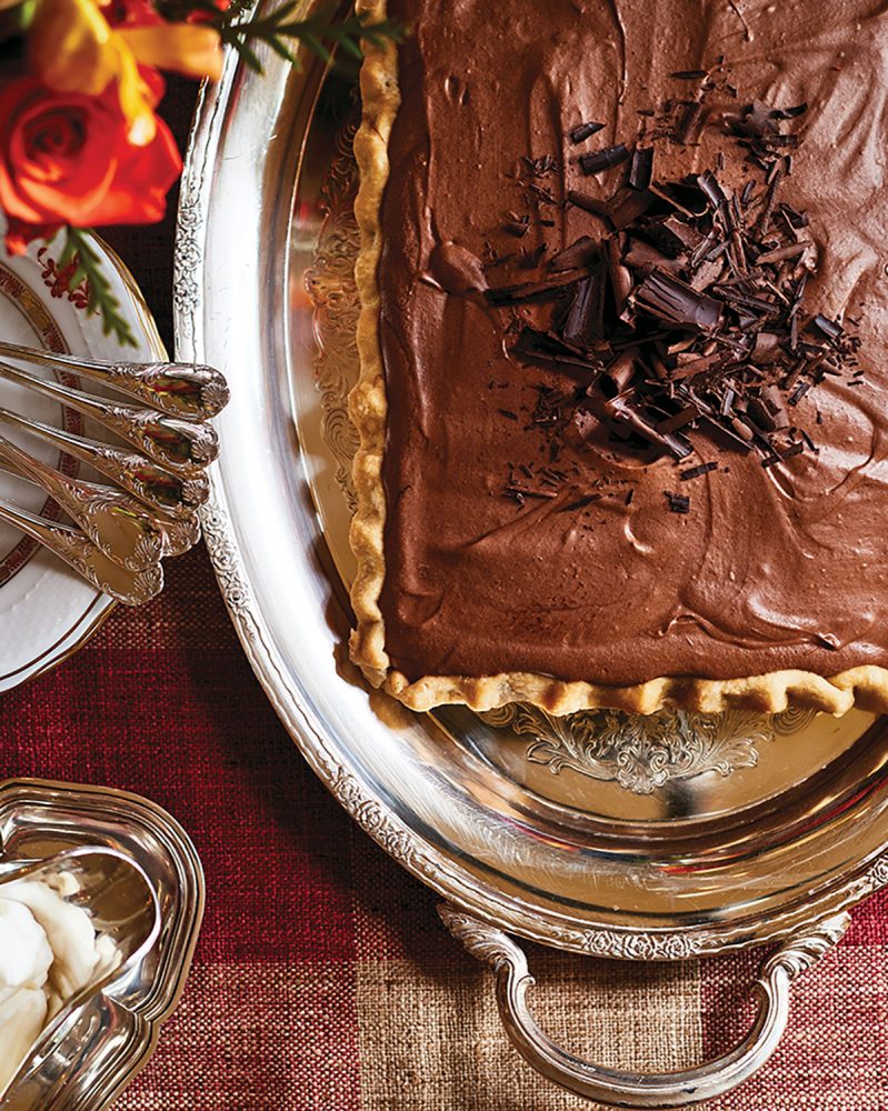 A chocolate dessert tart on a silver platter from The Art of the Host by Alex Hitz