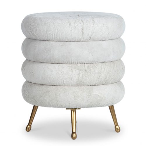white circular stool with for brass-toned legs. A linear pattern around the sides makes the stool appear as if it comprises for stacked disks