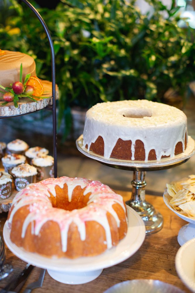 A variety of cakes and sweets on tiered trays and cake plates