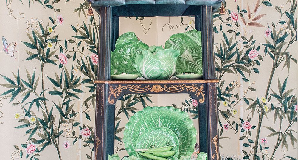 decorating with étagères, pagoda-shaped etagere, filled with green china, against chinoiserie wallpaper