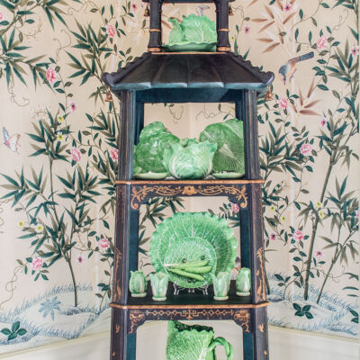 decorating with étagères, pagoda-shaped etagere, filled with green china, against chinoiserie wallpaper