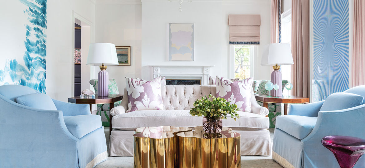 Bright pink and blue furniture make a white living room feel fun and airy.