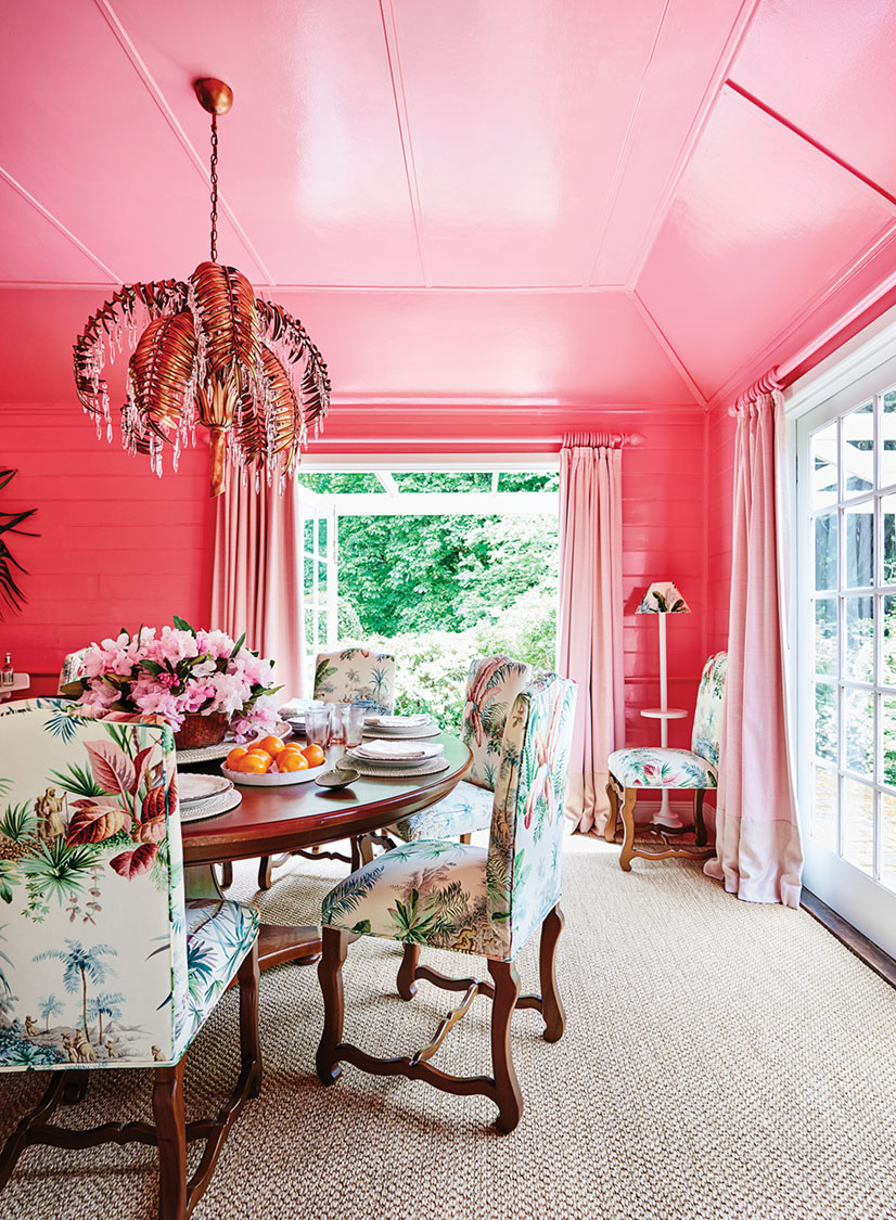 a pink dining room in the home of interior designer Charlotte Coote, featuring a tropical-inspired chandelier and upholstery