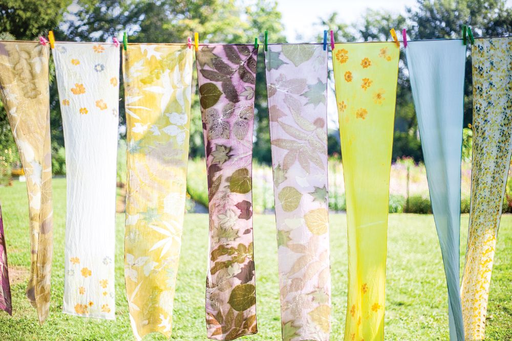 Flower printed scarves dry in the sun on a clothing line.