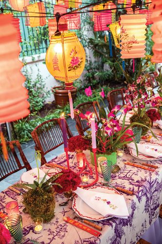 A Chinoiserie-themed party designed by Rebecca Gardner features glowing vintage Chinese lanterns, orchids, and a chinoiserie tablecloth
