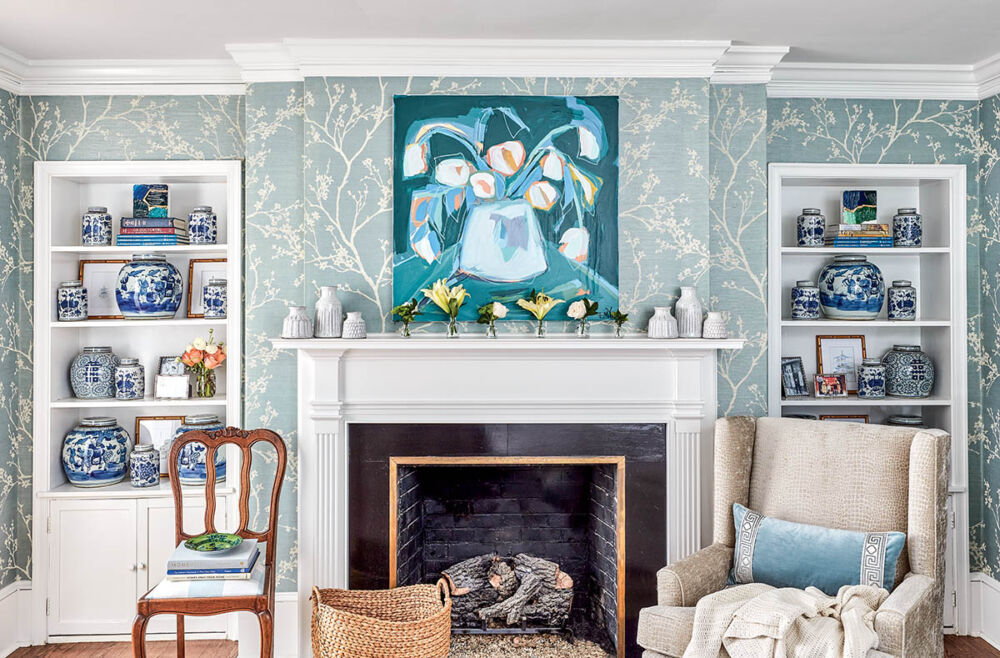 Fireplace with white mantel flanked by built-in bookcases filled with blue-and-white porcelain.