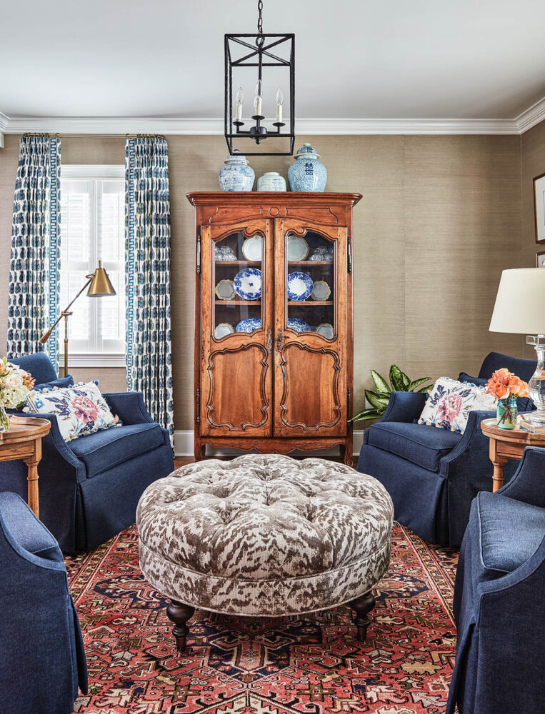 Four dark blue chairs grouped around an ottoman in the parlor of a 1940s cottage in Greenville.