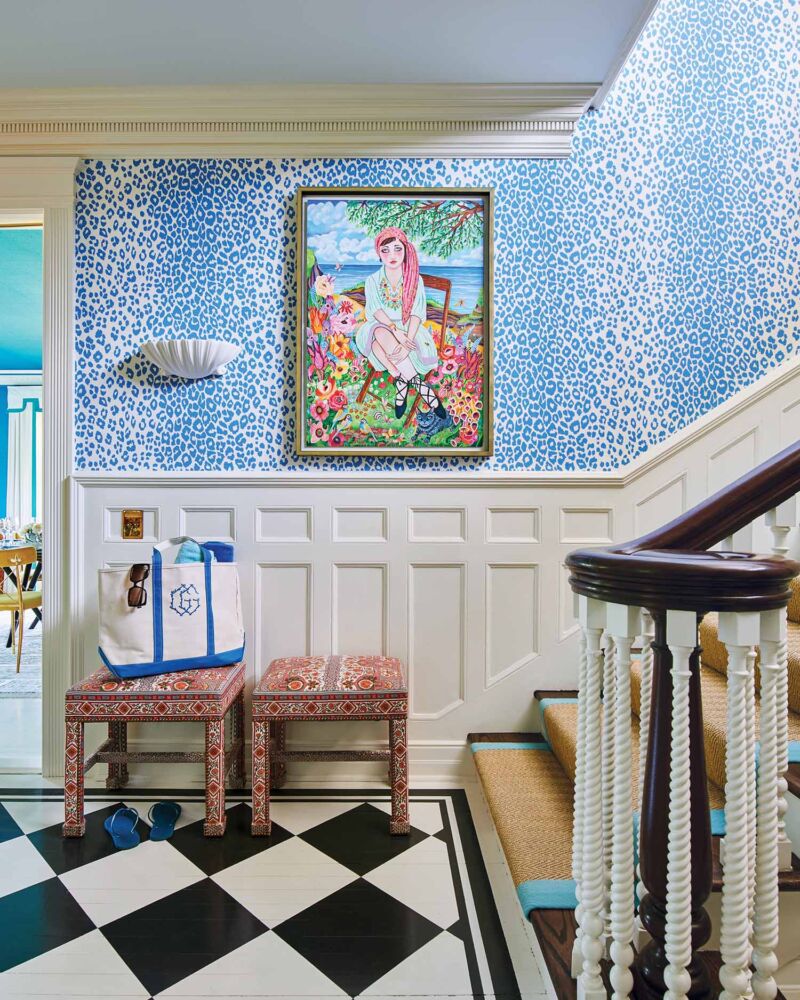 A cyan blue leopard print wallpaper lines the stairwell, punctuated by a whimsical portrait of a young woman by Helen Downing.