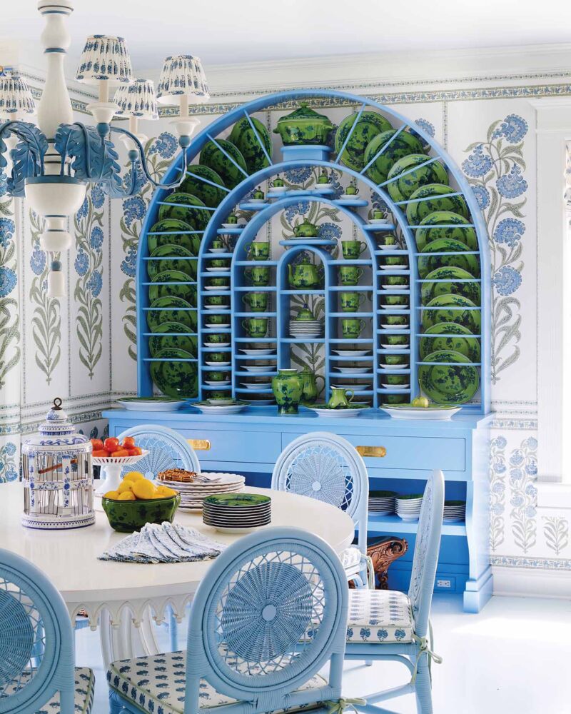 A cyan blue dome shaped hutch is filled with green floral plates and serveware.