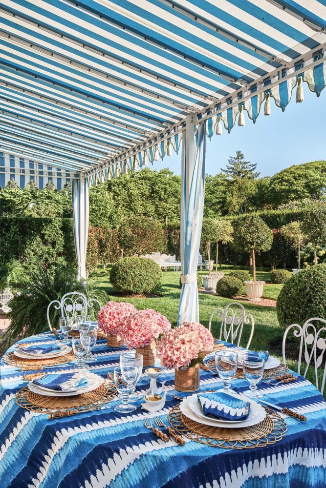 Blue stripes dominate in this outdoor table setting contrasted with pink hydrangeas.