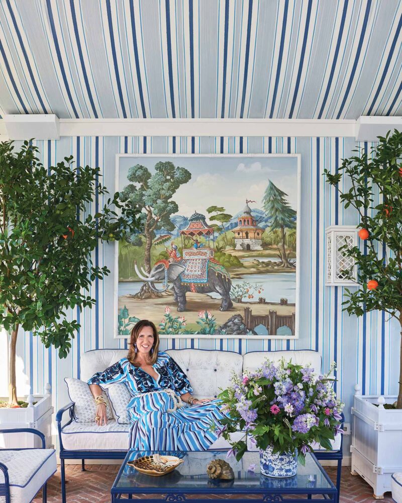 Liz Lange sits in a blue striped sun room.