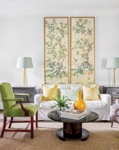 Two Japanese style painted murals hang over a white love seat.