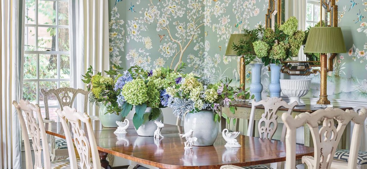 A chinoiserie wallpaper with a soft turquoise background envelope a bright dining room.