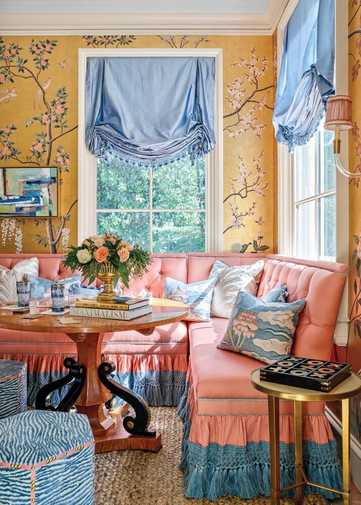 Mallory Mathison Glenn used contrasting materials like a chunky jute rug and dark woods to balance the Gracie wallpaper, dressmaker window treatments from The Shade Store, and tufted banquettes from Lillian August in this sitting room at the Flower Atlanta Showhouse