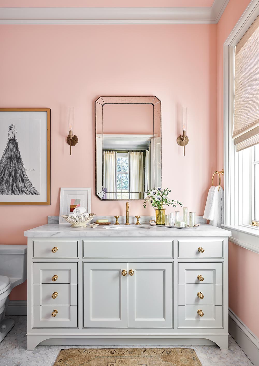 Bathroom sink and cabinet with pink walls in room designed by Tammy Connor