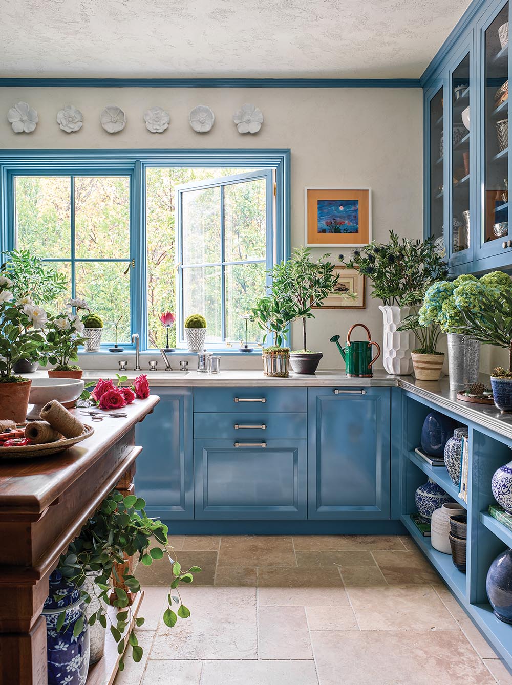 Glossy blue cabinets in a flower cutting room/laundry room designed by Bunny Williams.