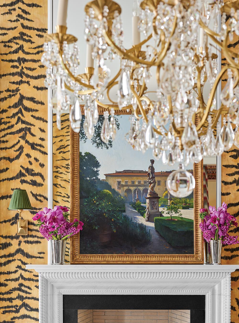 Bright gold and crystal chandelier in tiger-print dining room designed by Alexa Hampton.
