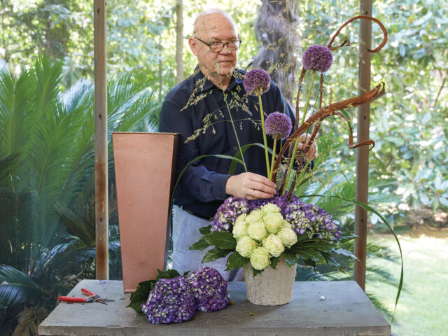 Bob Vardaman puts the finishing touches on a dramatic arrangement of hydrangeas, green tea roses, alliums, and grasses.