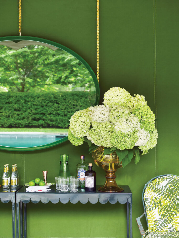 Big white hydrangeas overpower a glass bowl inside the green tent.