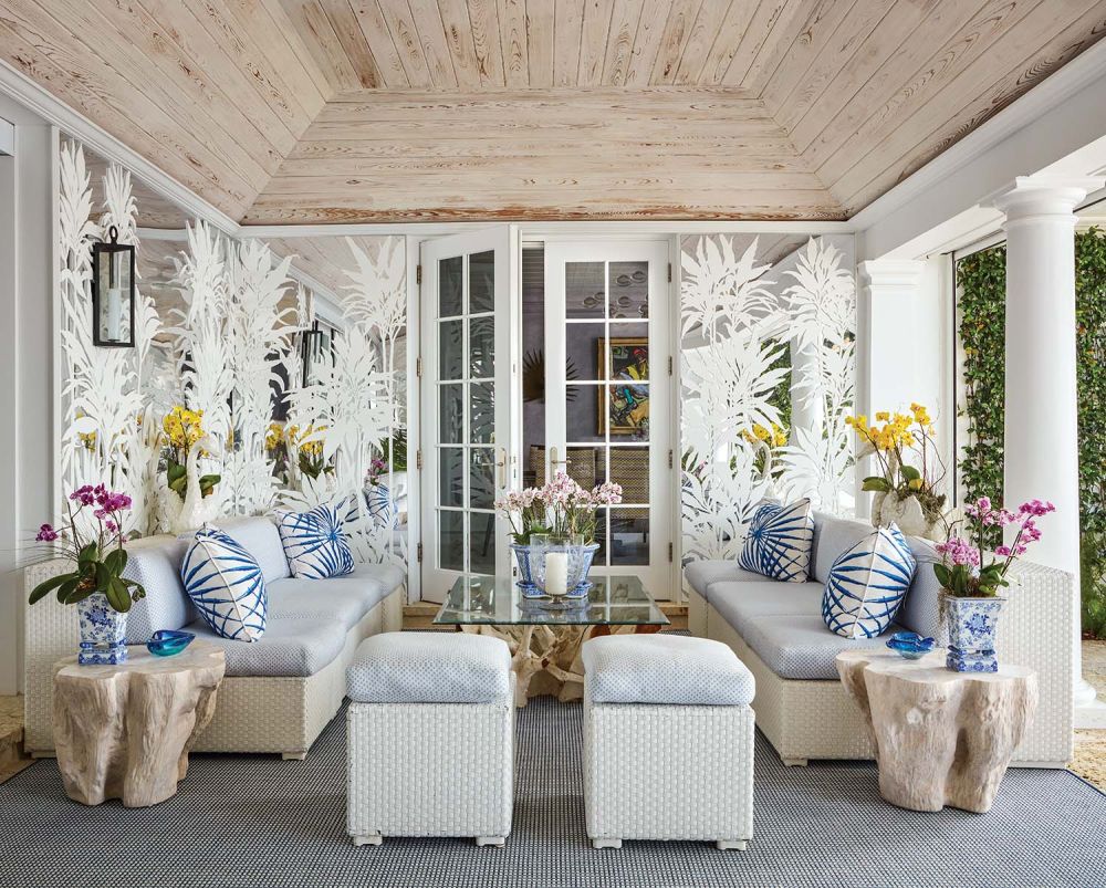 An outdoor patio has mirrors with painted florals.