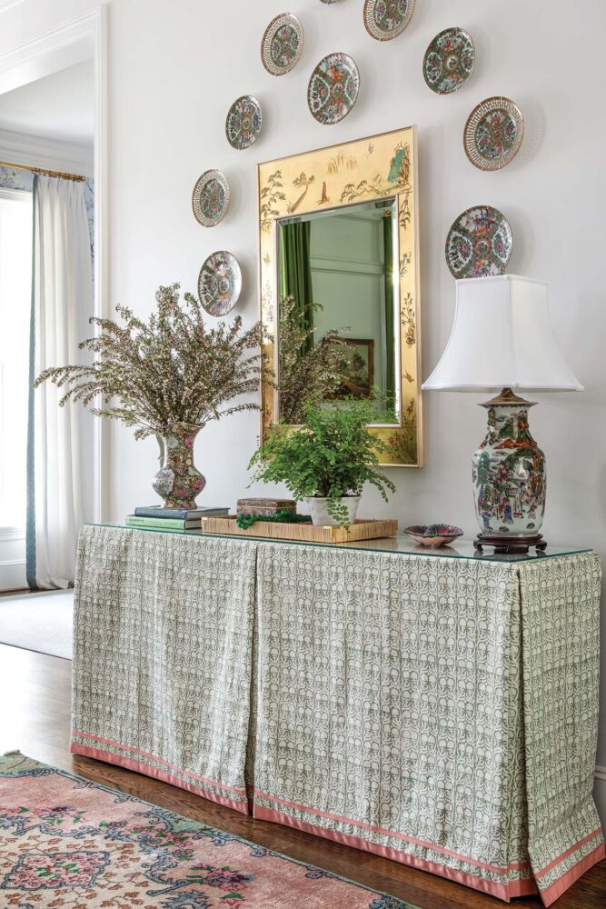 An entryway is decorate with chintz inspired green and pink decor.
