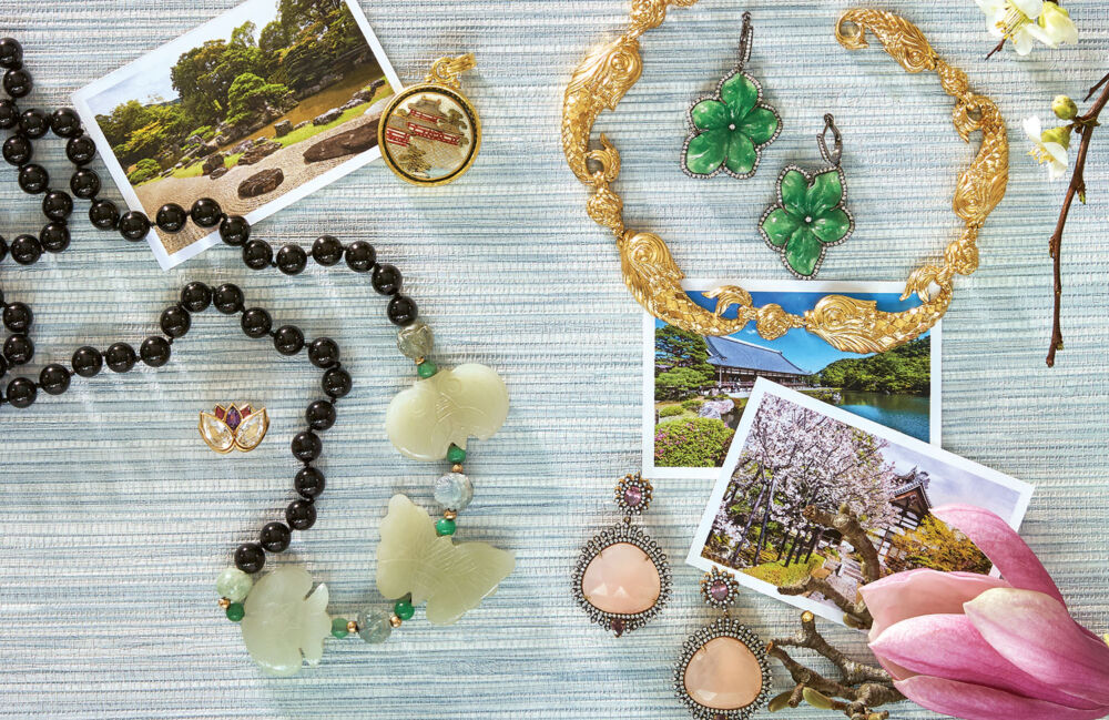 Jade floral earrings, a pendant necklace, and a gold koi fish necklace lay next to pictures of Hyakka'en Garden.