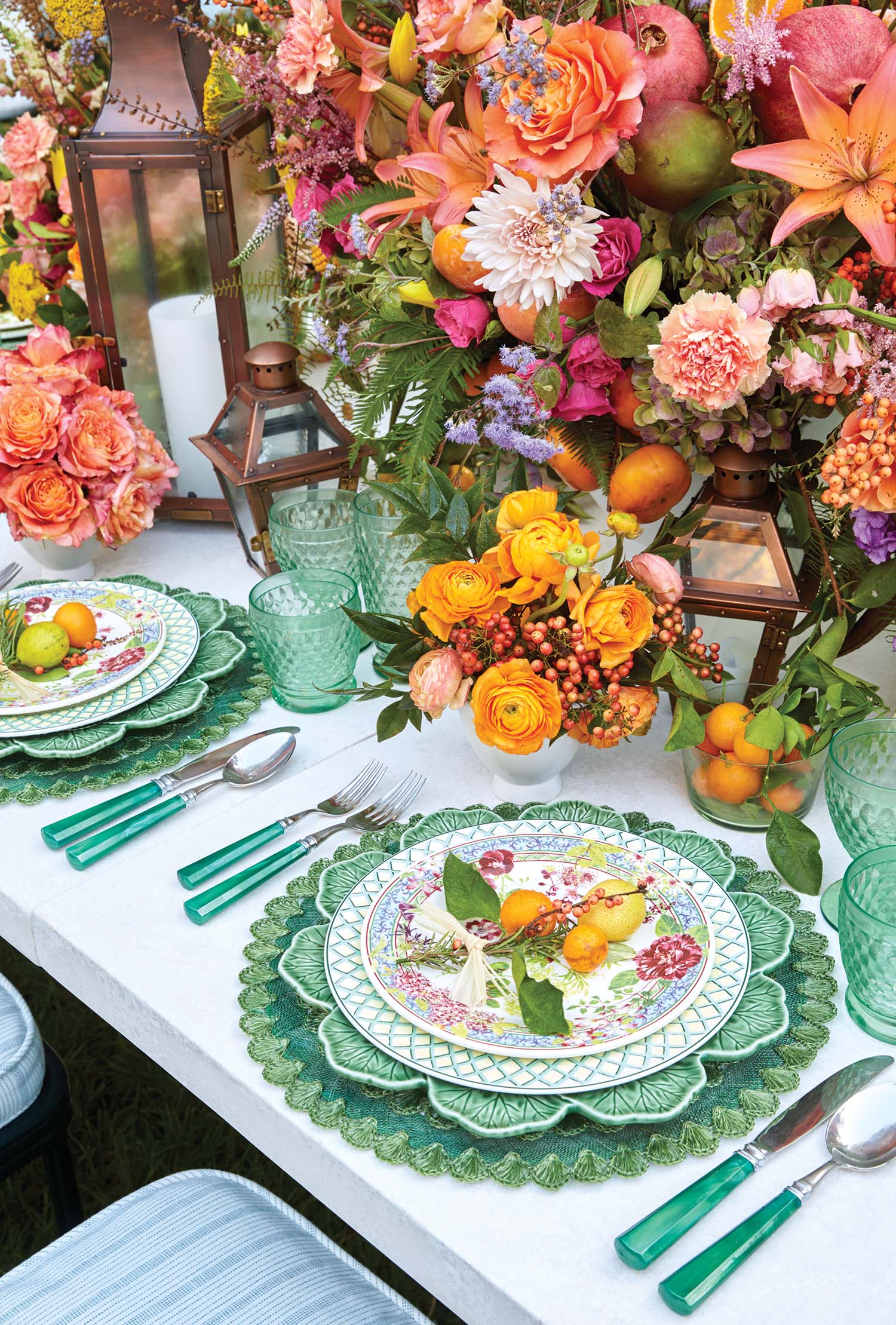 Bright orange and pink flowers adorn a table with turquoise table settings.