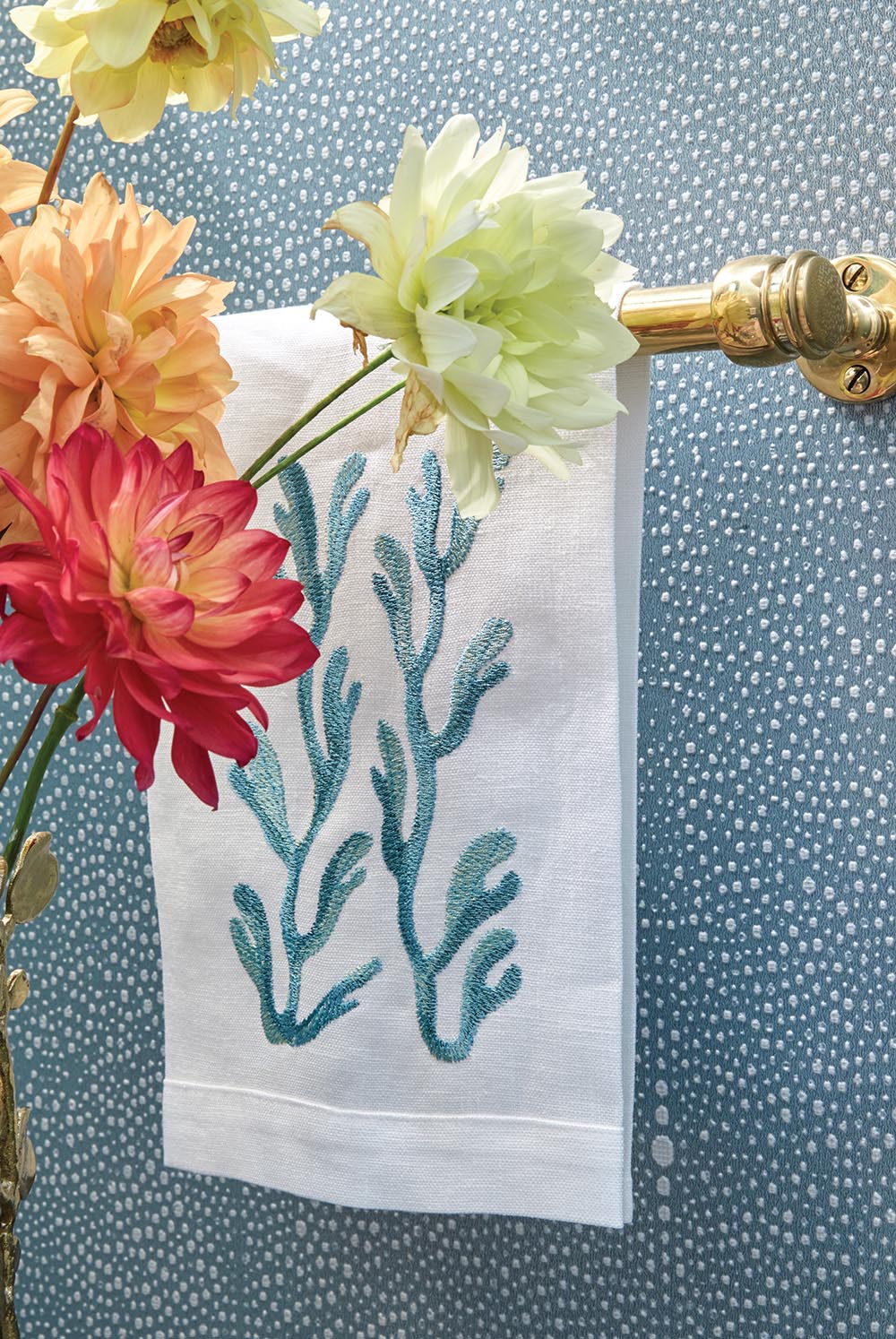 Close up of dahlia flowers and hand towel embroidered with coral in Nellie Howard Ossi designed powder room
