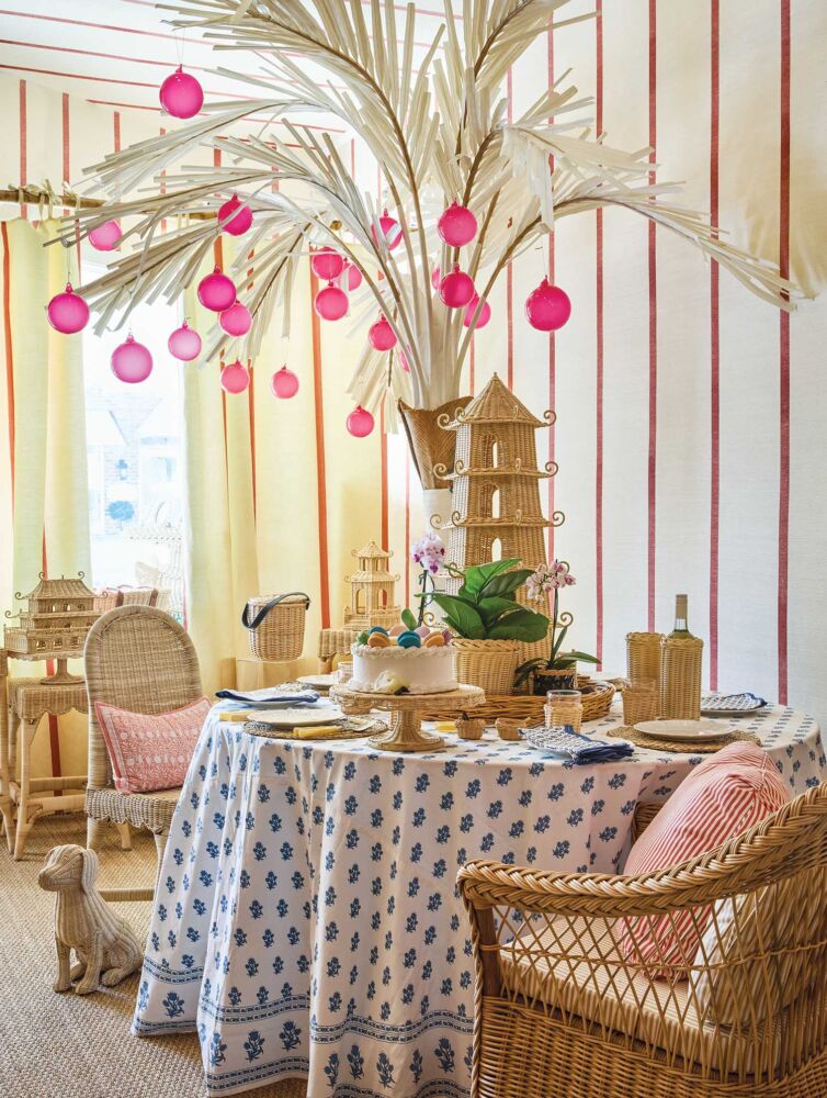 Vignette of wicker furniture and dried palm arrangement decorated with hot-pink ornaments in Amanda Lindroth's showroom.