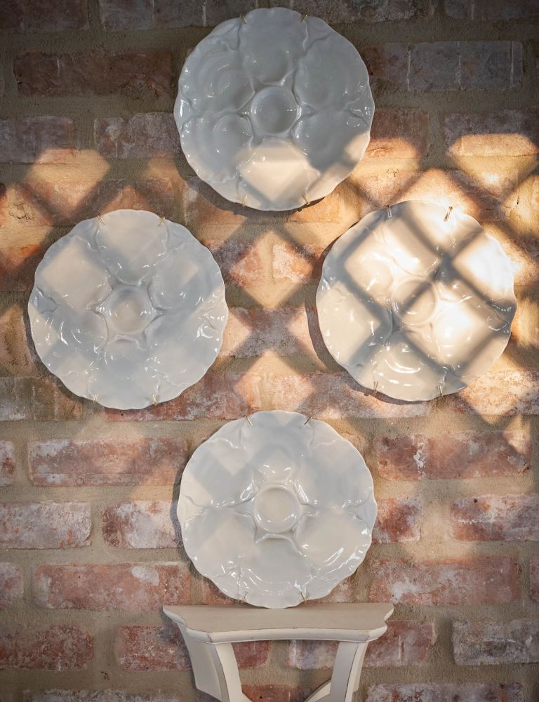 Ceramic floral plates hang on a wall.