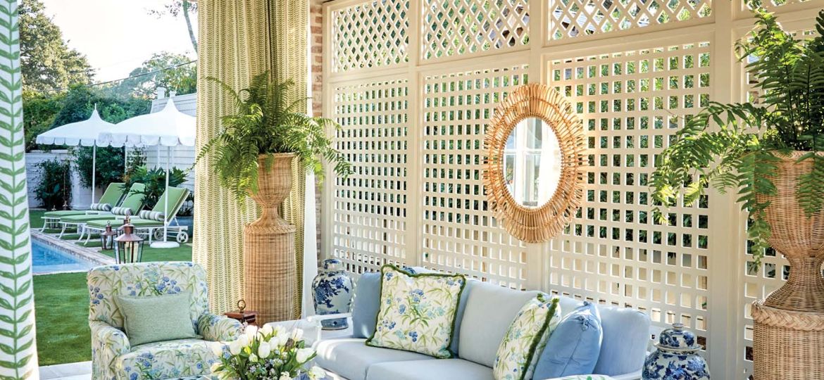 A cream colored lattice is the backdrop for a covered porch.